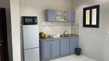 Appartement Deluxe, vue cour intérieure | Cuisine privée | Micro-ondes, batterie de cuisine, vaisselle et ustensiles