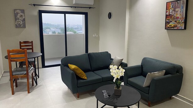 Una sala de estar con un sofá, una mesa de centro y un comedor con sillas.