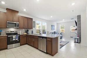 Een moderne keuken met roestvrijstalen apparatuur, houten kastjes en een groot eiland.
