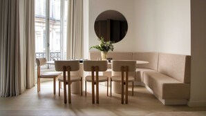 A modern living room with a sofa, a round table, and four chairs. - Luxury Flat -2br/6p- Madeleine/saint Honore (Paris)