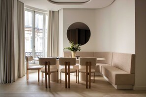Ein modernes Wohnzimmer mit einer Couch, einem runden Tisch und vier Stühlen.