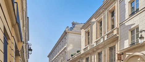 Une rangée de bâtiments classiques aux façades uniformes, dotés de grandes fenêtres et de balcons.