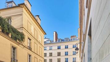 A multi-story building with a classic architectural style, featuring balconies and a clear blue sky.