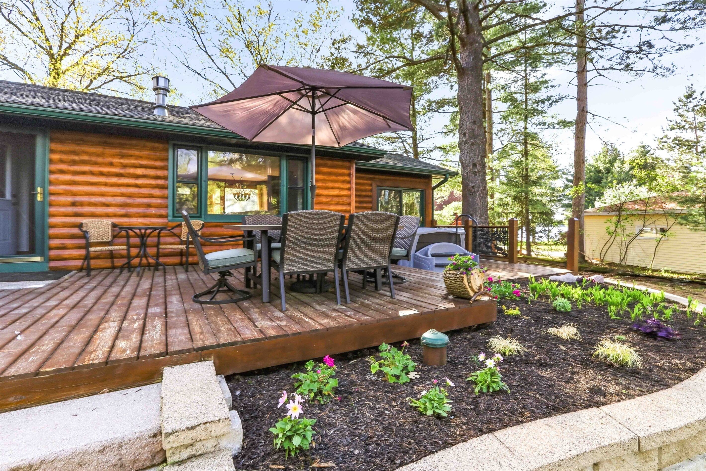 Une cabane en rondins dotée d’une terrasse, d’un espace salon extérieur et d’un jardin.