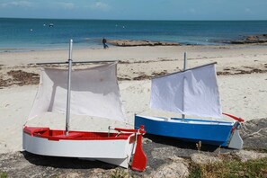 Two small boats on a sandy beach with a rocky shoreline and the sea in the background. - CARNAC 3-room apartment - sleeps 4 - sea view balcony (CARNAC)