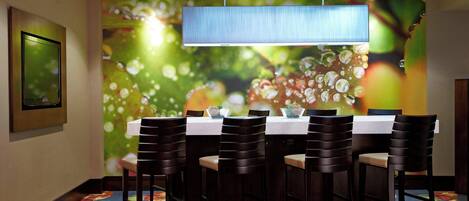 A conference room with a table, chairs, a television, and a colorful wall mural.