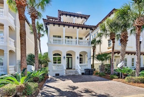 A multi-story building with a central courtyard, palm trees, and a brick pathway. - Ivory Palm — Private Pool, Gulf Views & Walk to Beach (Santa Rosa Beach)