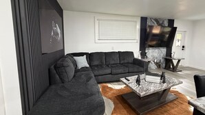 A modern living room with a sectional sofa, a coffee table, and a fireplace. - Modern Luxury Studio Cozy Retreat (Zephyrhills)