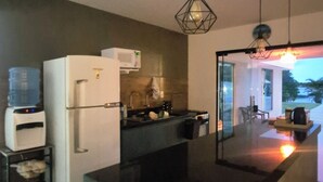 Cozinha moderna com ilha central, geladeira e micro-ondas.