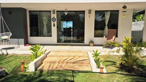 Uma casa moderna com um pátio, uma cadeira de balanço e uma poltrona.