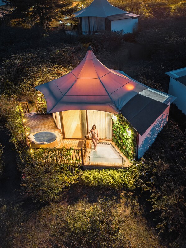 A tented accommodation with a hot tub, surrounded by vegetation. - Hemma Genki Luxury Wellness Hotel Villa  (Villa de Leyva)