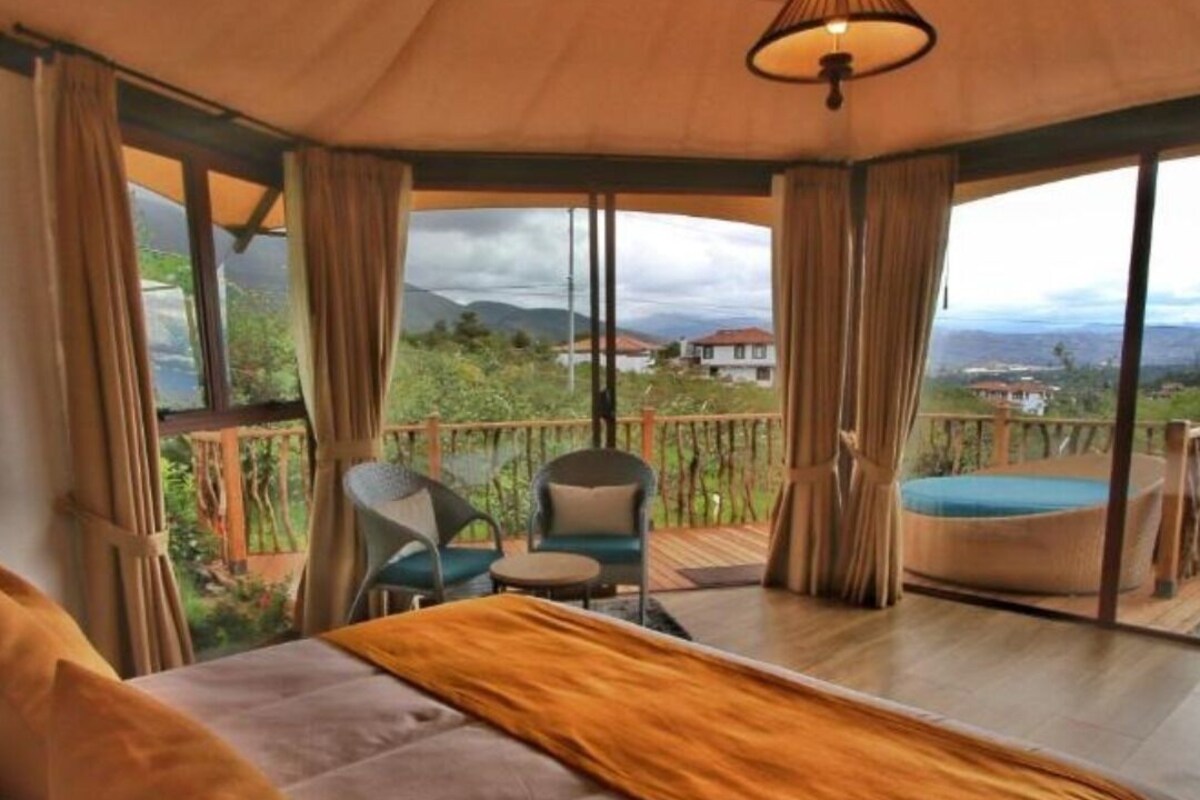 Un dormitorio con cama, una silla y vistas al exterior.