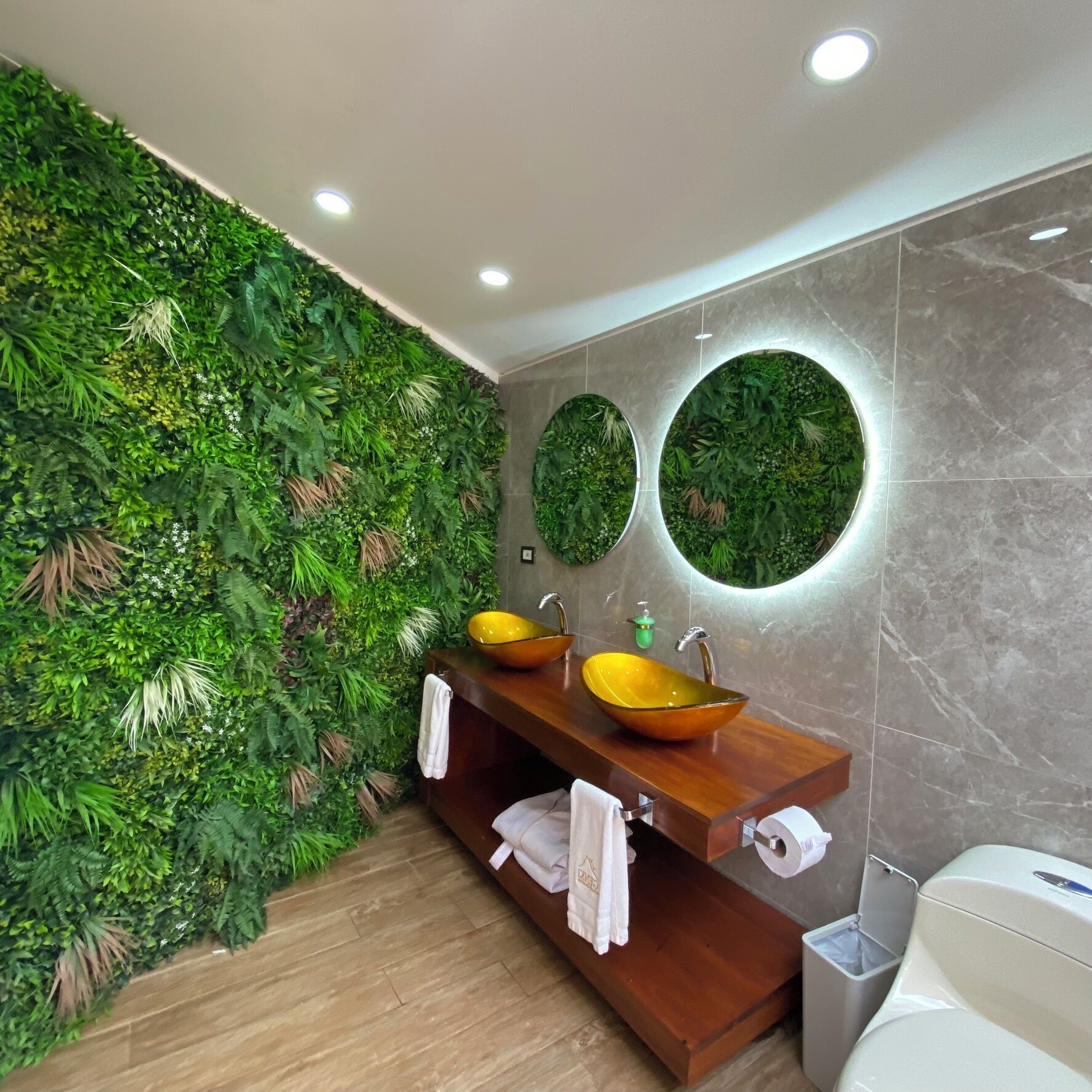 A bathroom with a green wall, two sinks with yellow bowls, and a mirror.