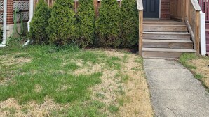 A residential building with a front porch, wooden steps, and a brick facade. - Gorgeous 3-bedroom townhome with AC in friendly Dundalk (Dundalk)