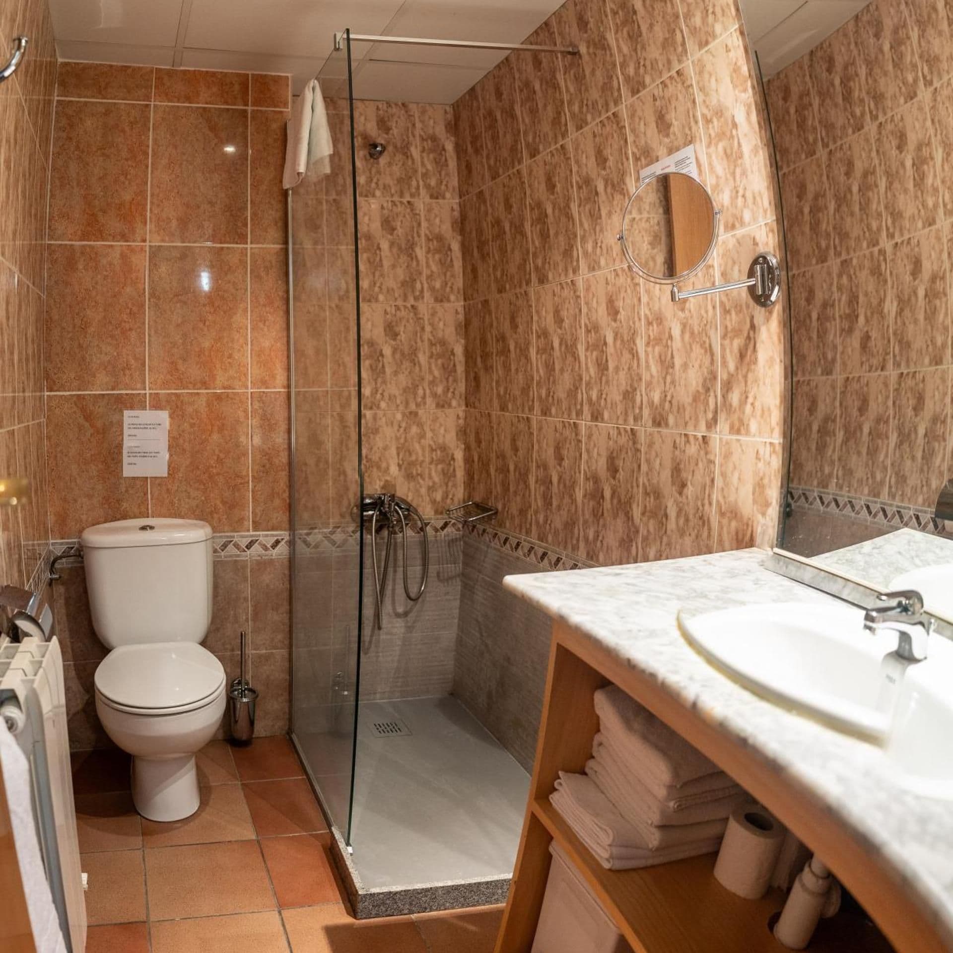 Une salle de bain équipée de toilettes, d’une douche et d’un lavabo avec un miroir.