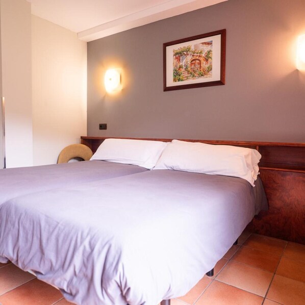 A hotel room with a large bed, a headboard, a wall-mounted light, and a framed picture. - Aparthotel Ransol (Ransol)