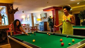 A pool table with balls, a woman in a yellow dress, and a woman in a red dress. - Aparthotel Ransol (Ransol)