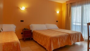 A hotel room with two beds, a nightstand, and a window with curtains. - Aparthotel Ransol (Ransol)