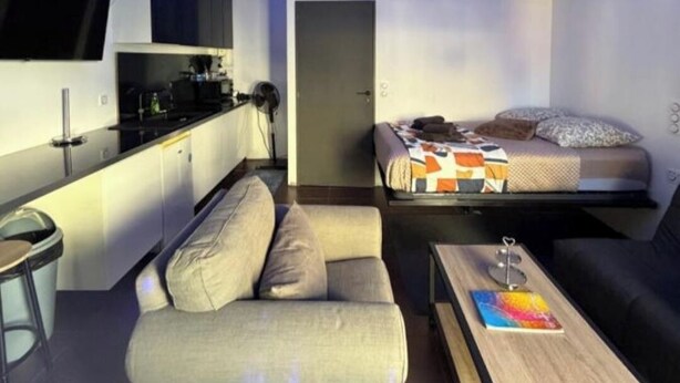 A compact living space with a kitchenette, a sofa, a coffee table, and a bed. - LoVe 3 au Falaises (Agde)
