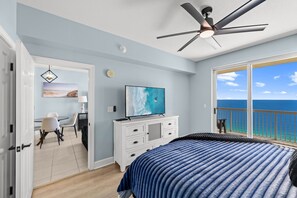 A bedroom with a large bed, a ceiling fan, a TV, and a view of the ocean. - 24th Floor Beach Front Condo! Amazing Views! (Panama City)