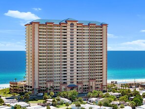 A multi-story hotel with balconies, located near a beach with clear blue water. - 24th Floor Beach Front Condo! Amazing Views! (Panama City)