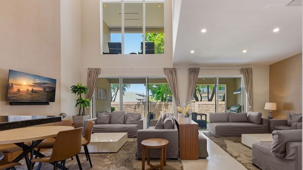 Un salón amplio con una mesa de comedor, sofás y un ventanal con vistas al exterior.