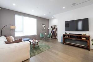 Una sala de estar moderna con sofá, mesa de centro, televisor y chimenea.