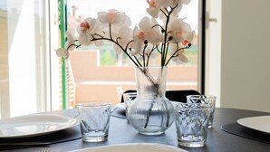 Een eettafel met een bloemenvaas, borden en bestek.