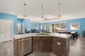 A modern kitchen with a central island, built-in appliances, and pendant lighting. - Timeless Hive: Dual Primary + Dual Kitchen, Five-Bedroom, 3600 SF Family Retreat (Parowan)