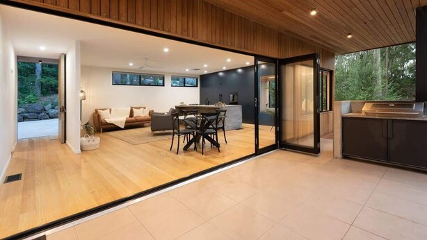 A modern interior with a dining area, sofa, and kitchen.