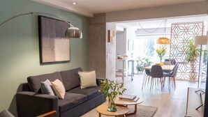 Ein modernes Wohnzimmer mit einer Couch, einem Couchtisch und einem Essbereich mit Stühlen und einem Tisch.