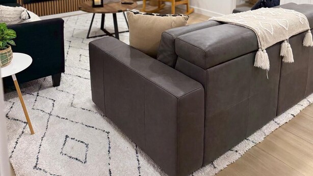 Una sala de estar moderna con un sofá, televisión, chimenea y comedor.