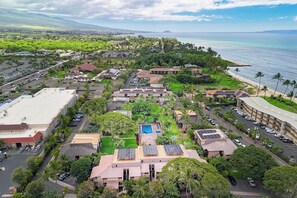 An aerial view of a resort with multiple buildings, a swimming pool, and a beach. - Kihei Garden Estates G205 Close to Beach and Stores (Kihei)