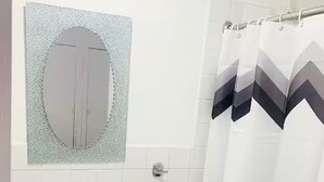 A bathroom with a white sink, a mirror, and a shower curtain.