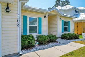 A two-story house with a number '308' on the side, a front porch, and a wooden fence. - Mermaid Manor (Panama City Beach)