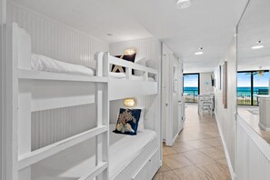 A bunk bed with a decorative pillow and a wall-mounted light fixture. - Sundestin 205 (Destin)