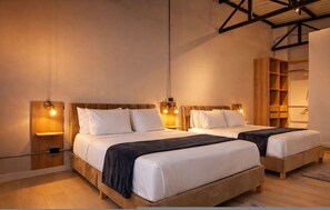 Ett hotellrum med två sängar, sänggavlar i trä, sänglampor, en garderob och en hängande lampa.