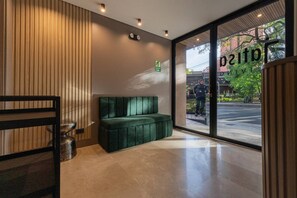 A modern interior with a green sofa, a wooden wall, and a glass door leading outside. - Jatisa 402 in Medell n (Medellín)