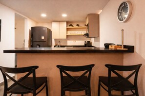 A kitchen with a refrigerator, a clock, and three chairs. - Oslo 701 in Medell n (Medellín)