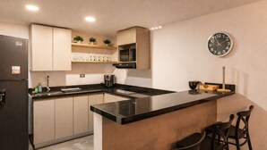 A modern kitchen with a black refrigerator, a microwave, and a clock on the wall. - Oslo 701 in Medell n (Medellín)