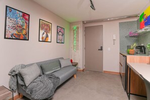A modern living space with a grey sofa, a kitchen area, and artwork on the walls. - Ayamonte 301a in Medell n (Medellín)