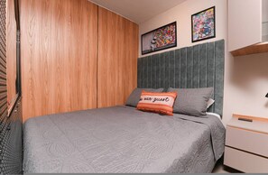 A bedroom with a bed, a nightstand, a wooden wardrobe, and two framed pictures on the wall. - Ayamonte 301a in Medell n (Medellín)