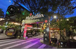 A pedestrian crossing with a sign for Medellin, surrounded by outdoor seating and potted plants. - Oslo 604a in Medell n (Medellín)