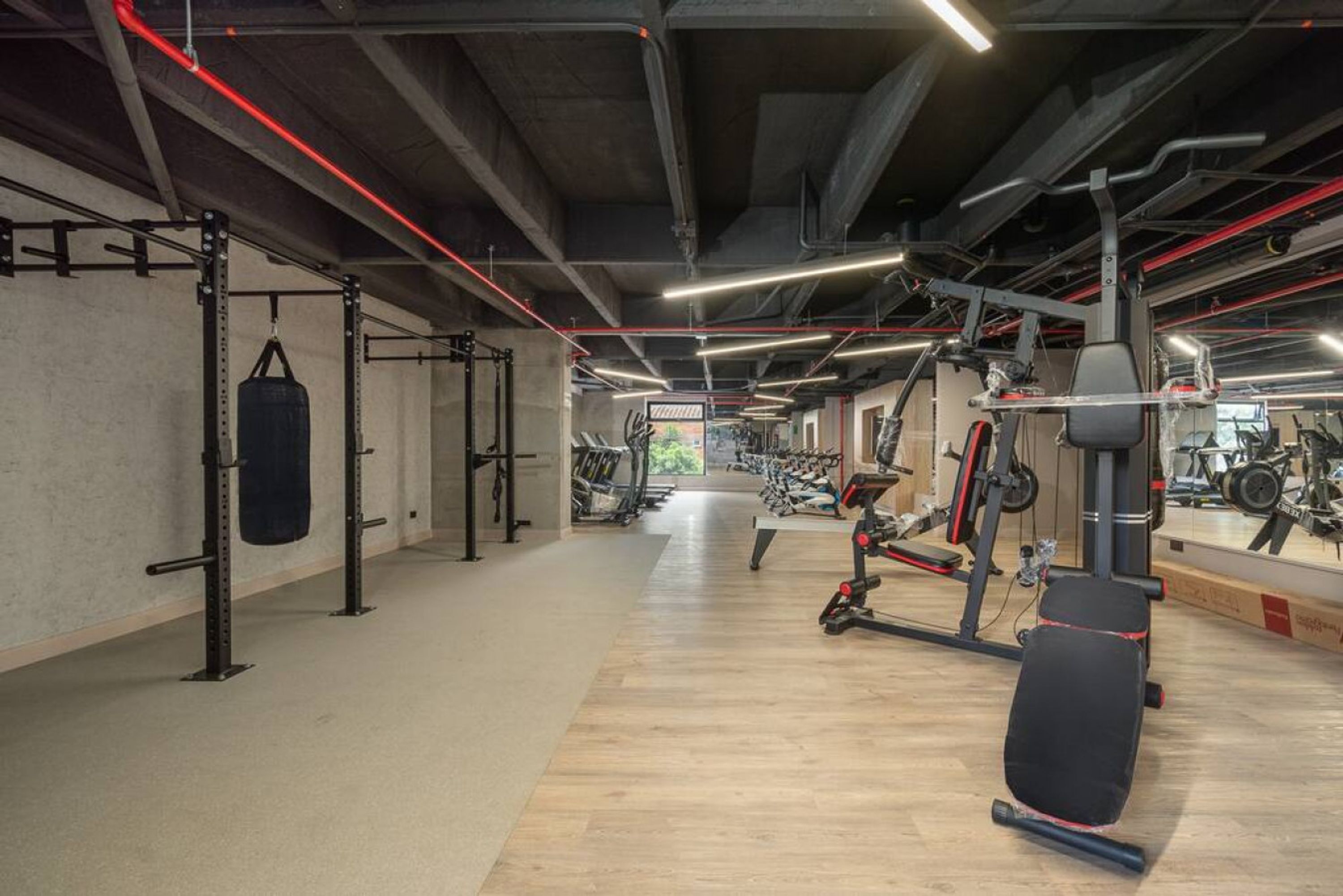 A gym with weightlifting equipment, a punching bag, and exercise machines.