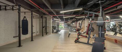 A gym with weightlifting equipment, a punching bag, and exercise machines.