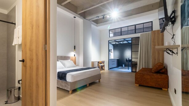 Un dormitorio moderno con cama, mesita de noche y puerta de madera.