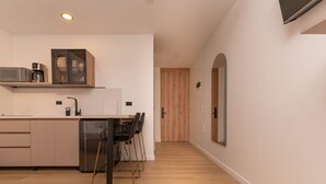 A modern kitchen with a microwave, coffee maker, and a cabinet. There are chairs and a dishwasher. - Opera 301 in Medell n (Medellín)