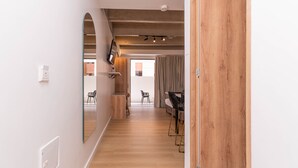 A hallway with a wooden floor, a large mirror, and a television mounted on the wall. - Opera 301 in Medell n (Medellín)