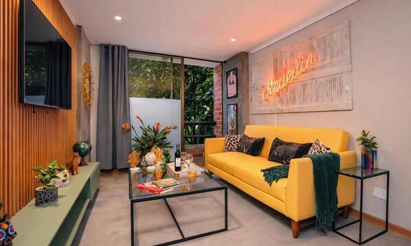 A modern living room with a yellow sofa, glass coffee table, and a neon sign on the wall. - Ayamonte - 301b in Medell n (Medellín)