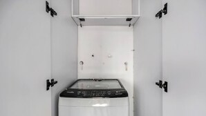 A compact washing machine in a white cabinet with a control panel, located in a small, enclosed space. - Oslo 2101 in Medell n (Medellín)